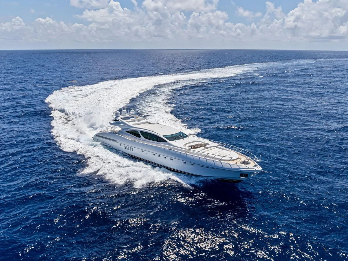 A sleek yacht cruises through the open ocean, leaving a trail of white wake behind. aboard INCOGNITO Yacht for Sale