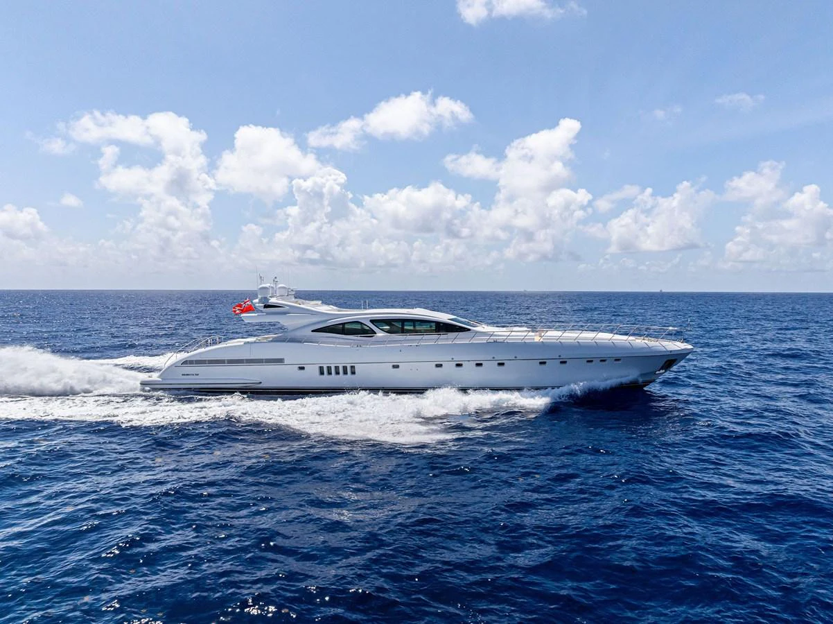A sleek and modern yacht cruising through the open sea under a bright blue sky. aboard INCOGNITO Yacht for Sale