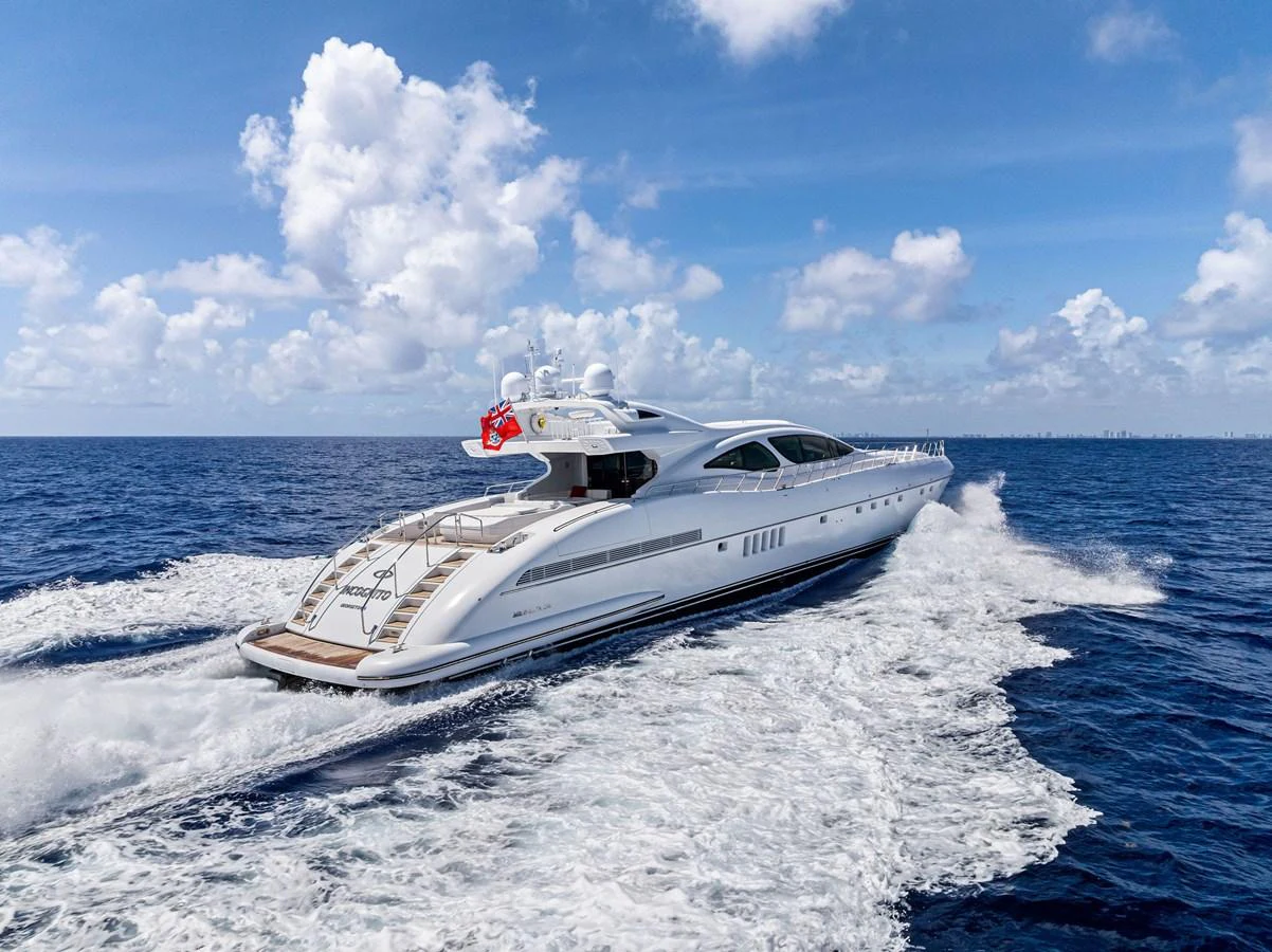 A sleek and modern yacht cruises through the open sea, leaving a trail of white wake behind. aboard INCOGNITO Yacht for Sale