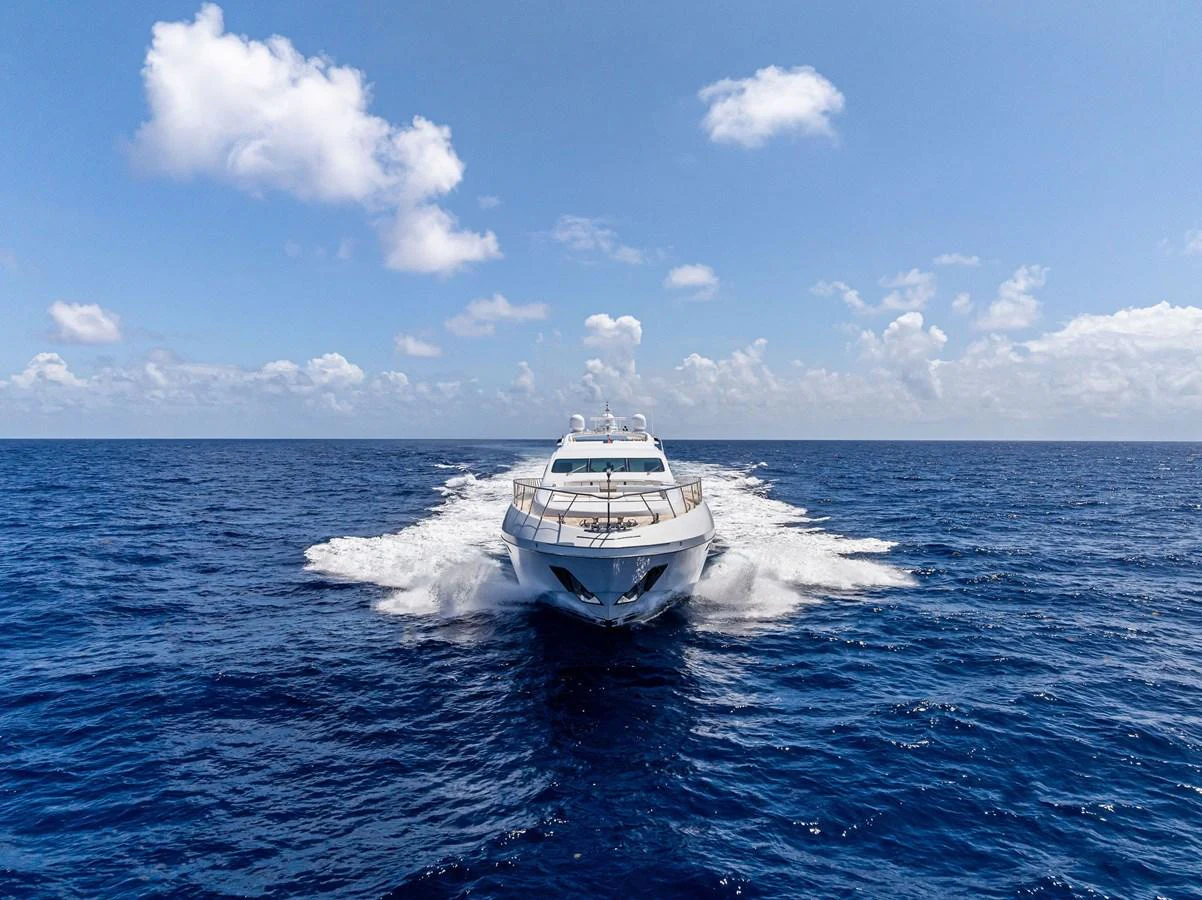 A sleek yacht cruises through the open ocean under a bright blue sky. aboard INCOGNITO Yacht for Sale
