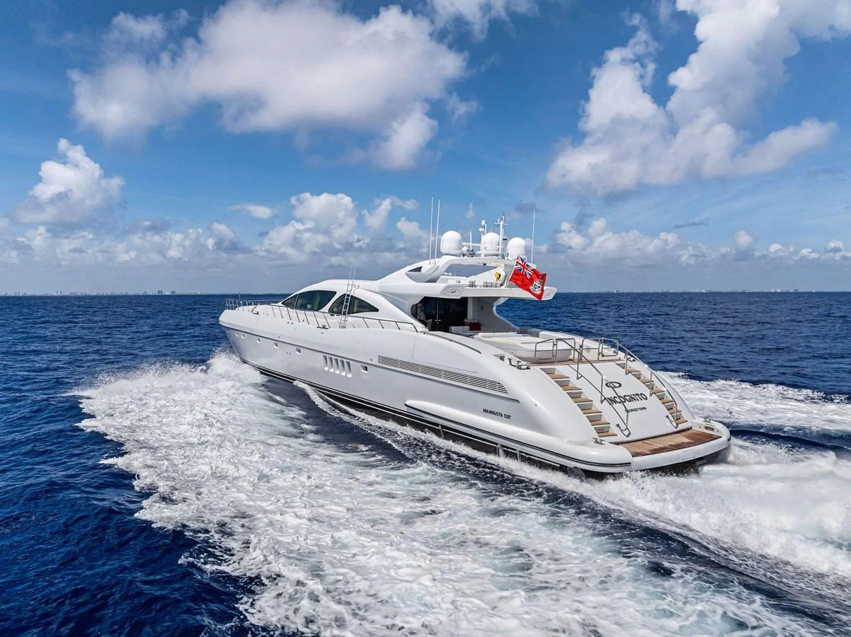 A sleek and modern yacht cruises through the open sea under a bright blue sky. aboard INCOGNITO Yacht for Sale