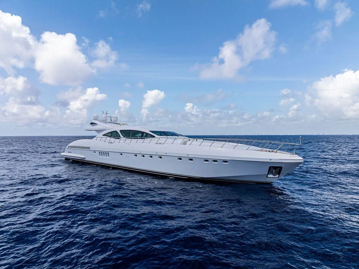 A sleek, modern yacht cruises on the open sea under a bright, partly cloudy sky. aboard INCOGNITO Yacht for Sale