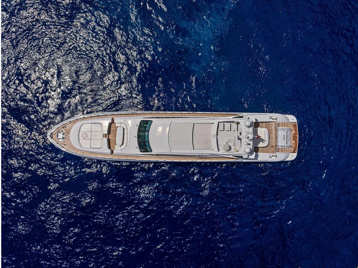 A stunning aerial view of a sleek yacht cruising through deep blue waters. aboard INCOGNITO Yacht for Sale