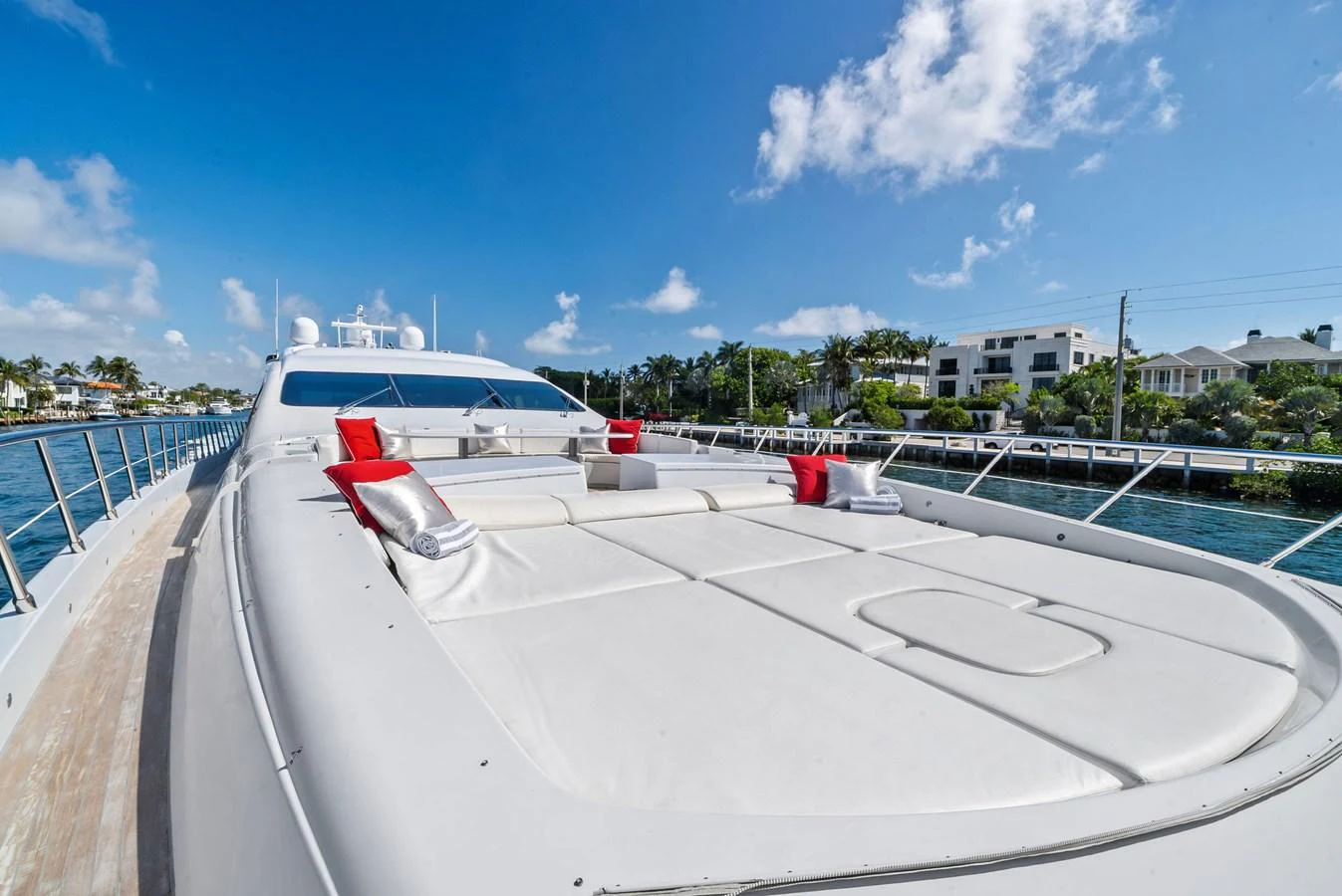 The foredeck of this yacht features spacious sun pads with plush red and white cushions, perfect for lounging under the sun. aboard INCOGNITO Yacht for Sale