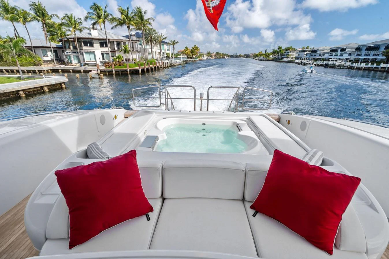 The aft deck features a luxurious jacuzzi with plush seating and vibrant red cushions, perfect for relaxation while cruising. aboard INCOGNITO Yacht for Sale