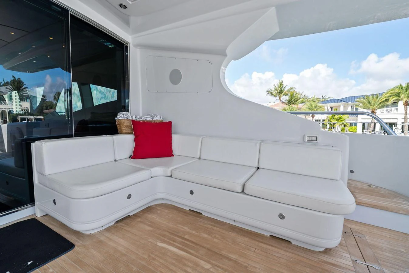 The aft deck features a comfortable white sectional sofa with a vibrant red cushion, perfect for relaxation. aboard INCOGNITO Yacht for Sale
