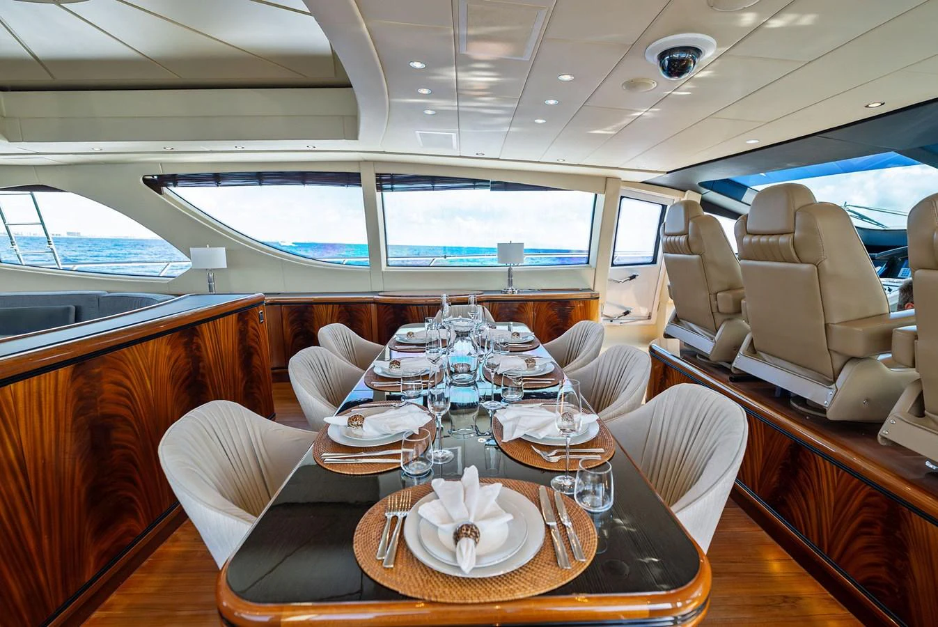 The yacht's dining area features a beautifully set table with elegant place settings and a panoramic view of the sea. aboard INCOGNITO Yacht for Sale