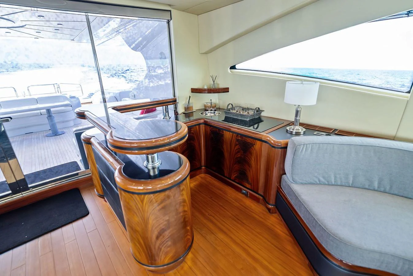 The yacht's salon features elegant woodwork, a comfortable seating area, and a view of the aft deck through large windows. aboard INCOGNITO Yacht for Sale