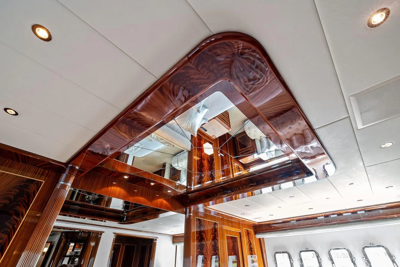 The yacht's interior features a luxurious ceiling with intricate woodwork and mirrored panels, creating an elegant and spacious ambiance. aboard INCOGNITO Yacht for Sale
