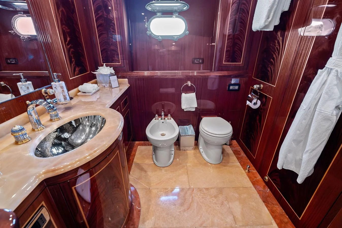 The yacht's bathroom features luxurious wood paneling and high-end fixtures. aboard INCOGNITO Yacht for Sale