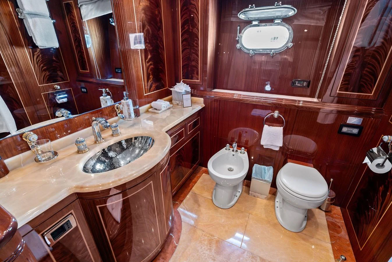 The yacht's bathroom features luxurious wood paneling and high-end fixtures. aboard INCOGNITO Yacht for Sale