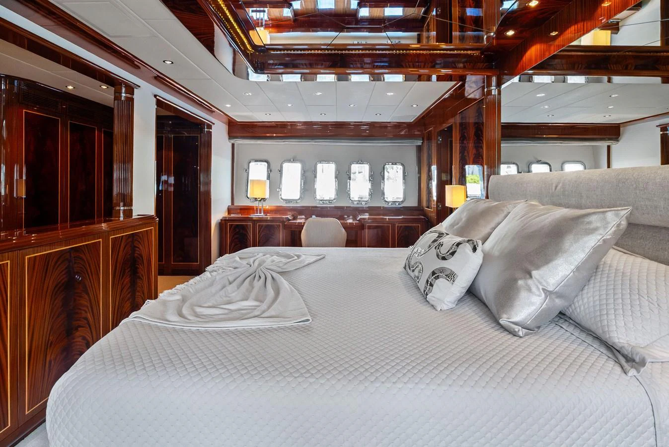 The master stateroom features luxurious bedding and elegant wood paneling, creating a serene and opulent atmosphere. aboard INCOGNITO Yacht for Sale
