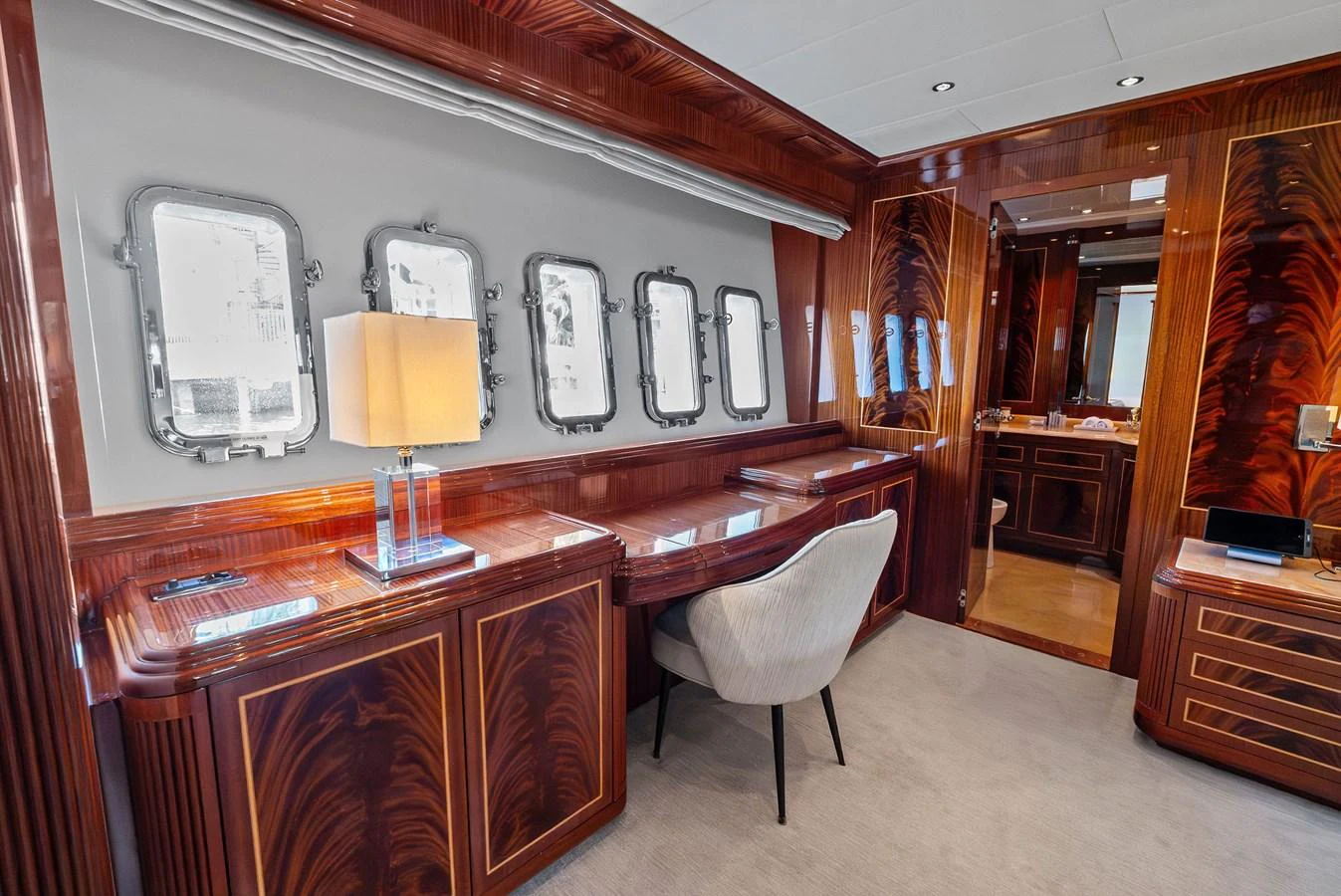 The stateroom features elegant wood paneling, a comfortable chair, and ample natural light from multiple windows. aboard INCOGNITO Yacht for Sale