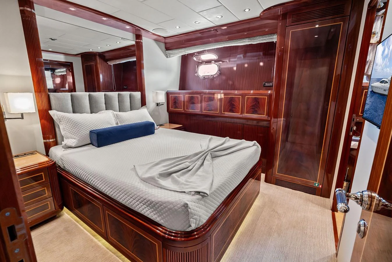 The stateroom features elegant wood paneling and a plush bed, creating a luxurious and inviting atmosphere. aboard INCOGNITO Yacht for Sale
