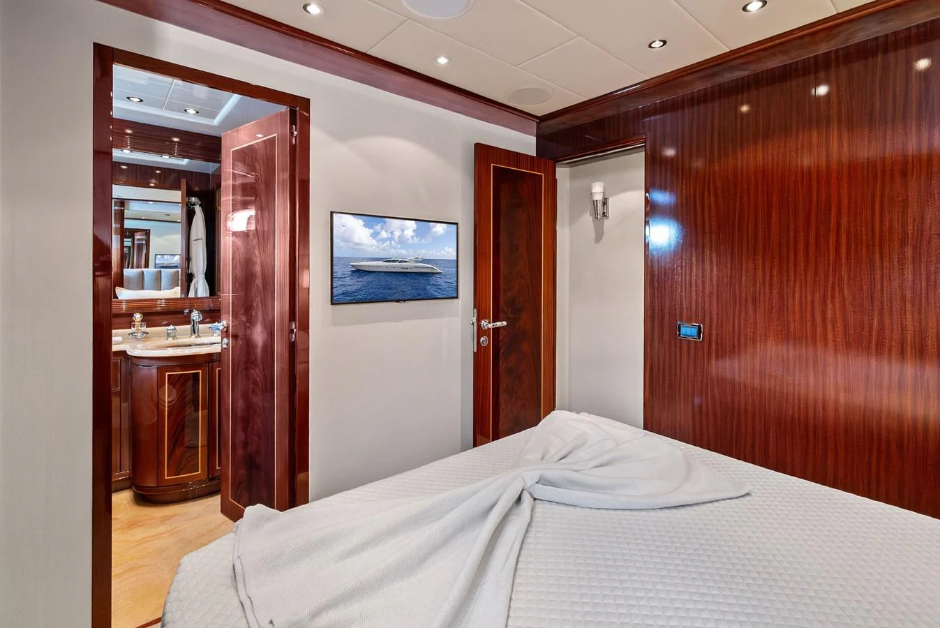 The stateroom features elegant wood paneling and a comfortable bed with an en-suite bathroom. aboard INCOGNITO Yacht for Sale