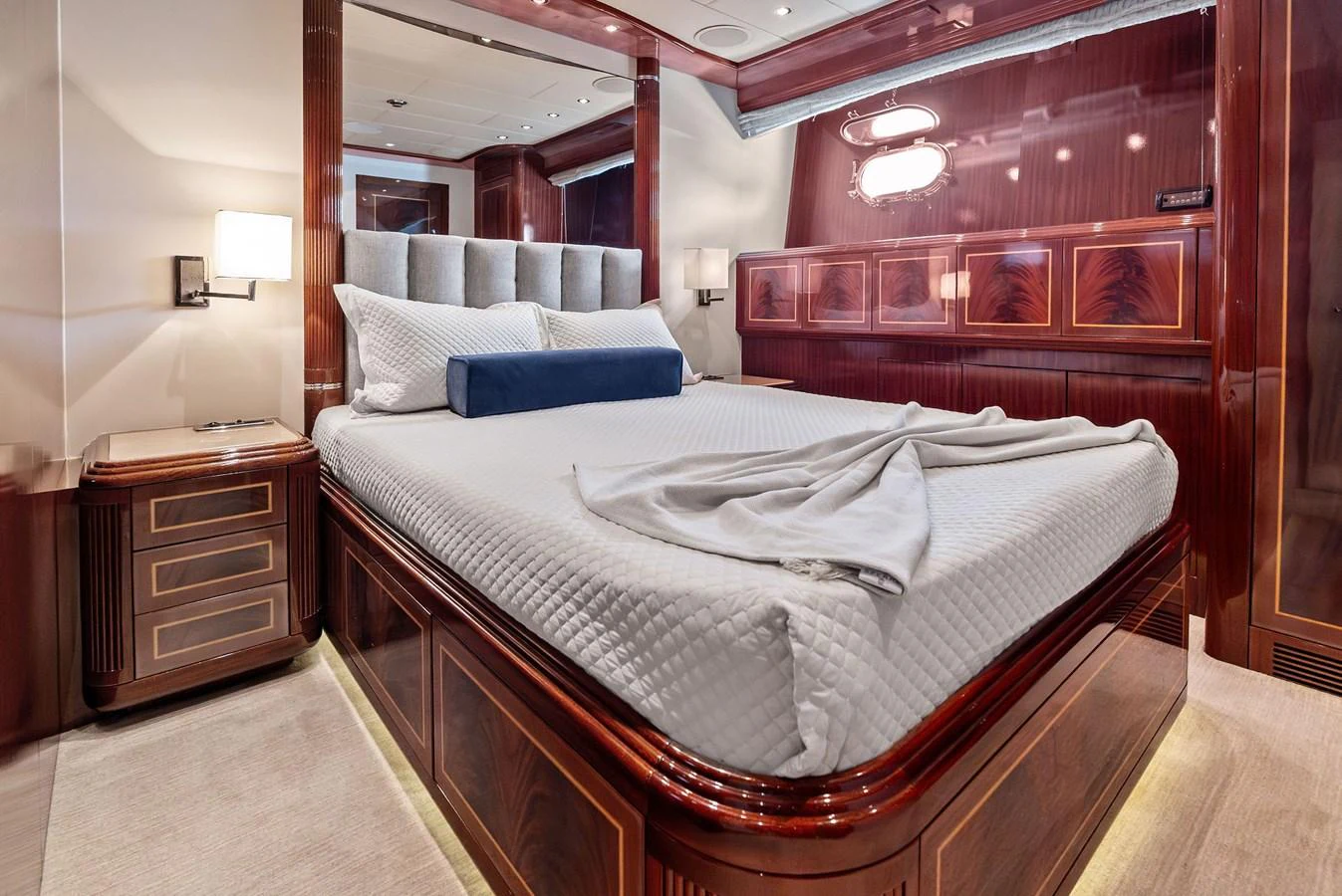 The stateroom features a luxurious bed with elegant wood finishes and ambient lighting. aboard INCOGNITO Yacht for Sale