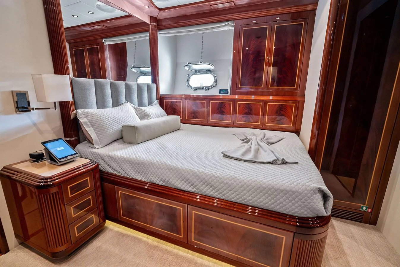 The stateroom features luxurious wood paneling and a plush bed with elegant bedding. aboard INCOGNITO Yacht for Sale