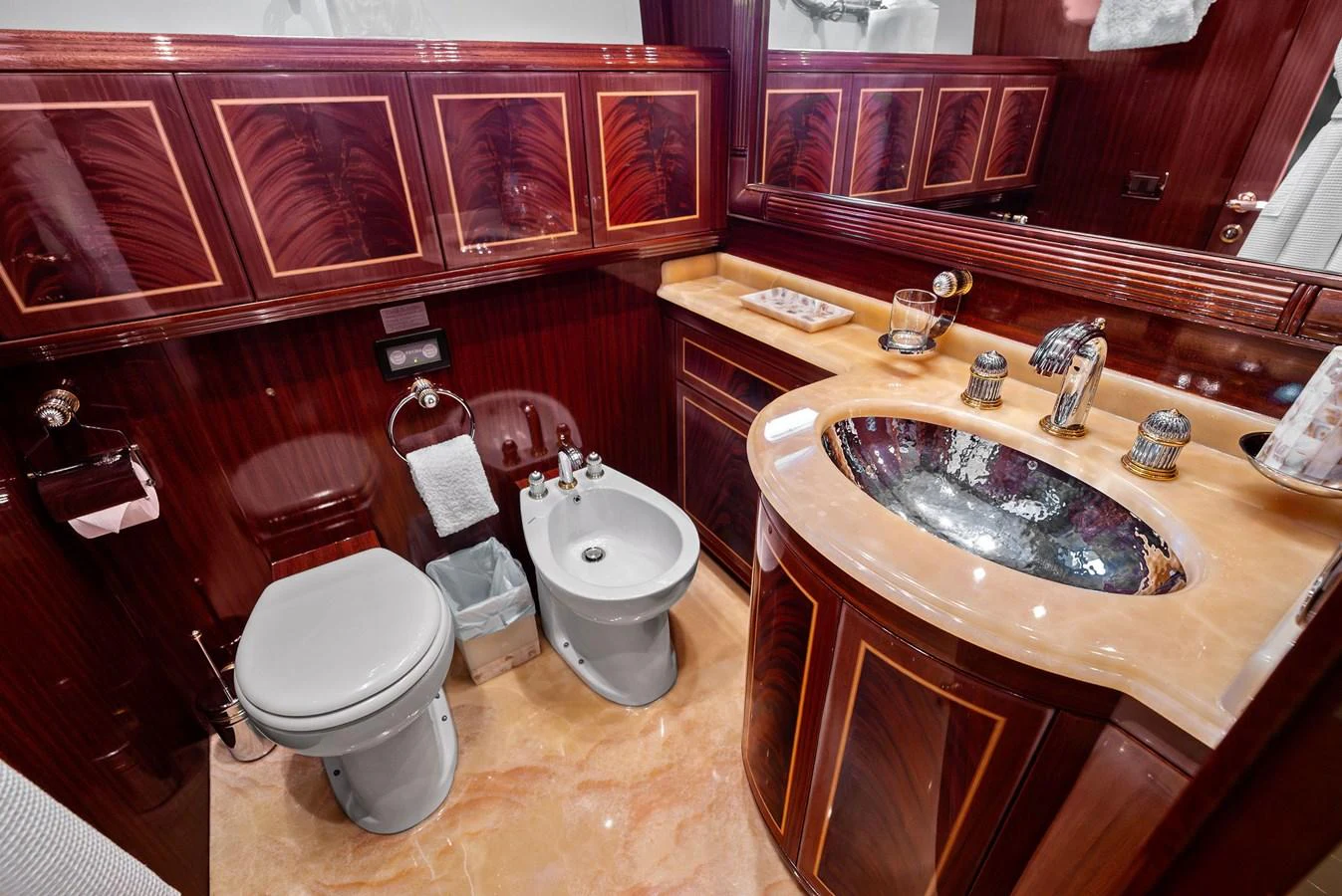 A luxurious yacht bathroom featuring elegant wood paneling and high-end fixtures. aboard INCOGNITO Yacht for Sale