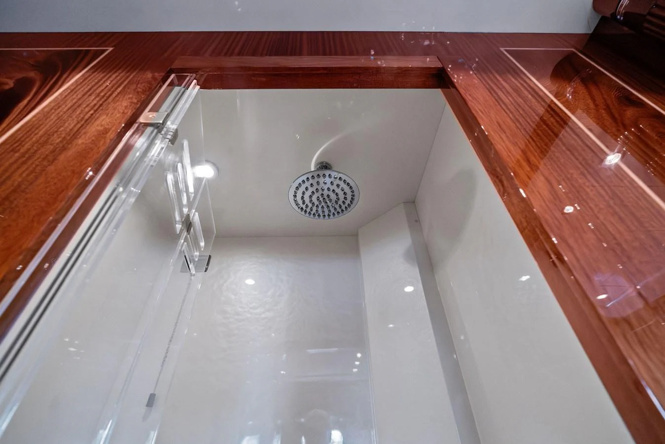 A luxurious shower area with a modern rain showerhead and elegant wood trim. aboard INCOGNITO Yacht for Sale
