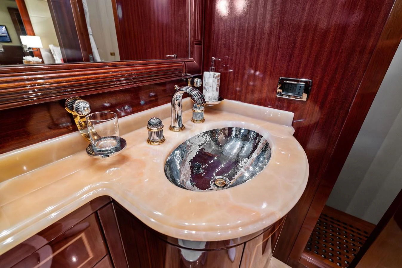 The yacht's bathroom features a luxurious sink with elegant fixtures and rich wood accents. aboard INCOGNITO Yacht for Sale