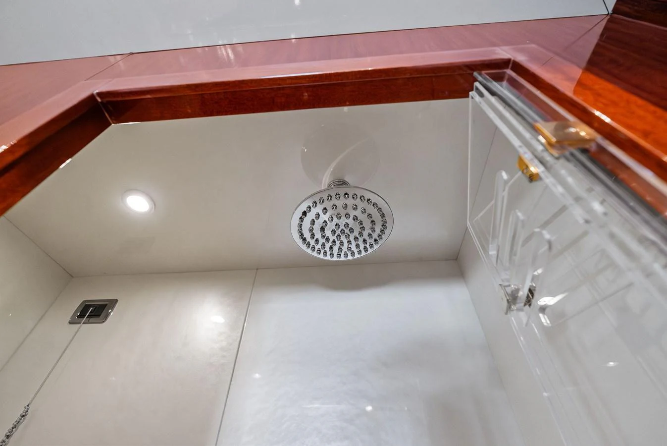 The image showcases a modern shower area with a sleek rain showerhead and elegant finishes. aboard INCOGNITO Yacht for Sale