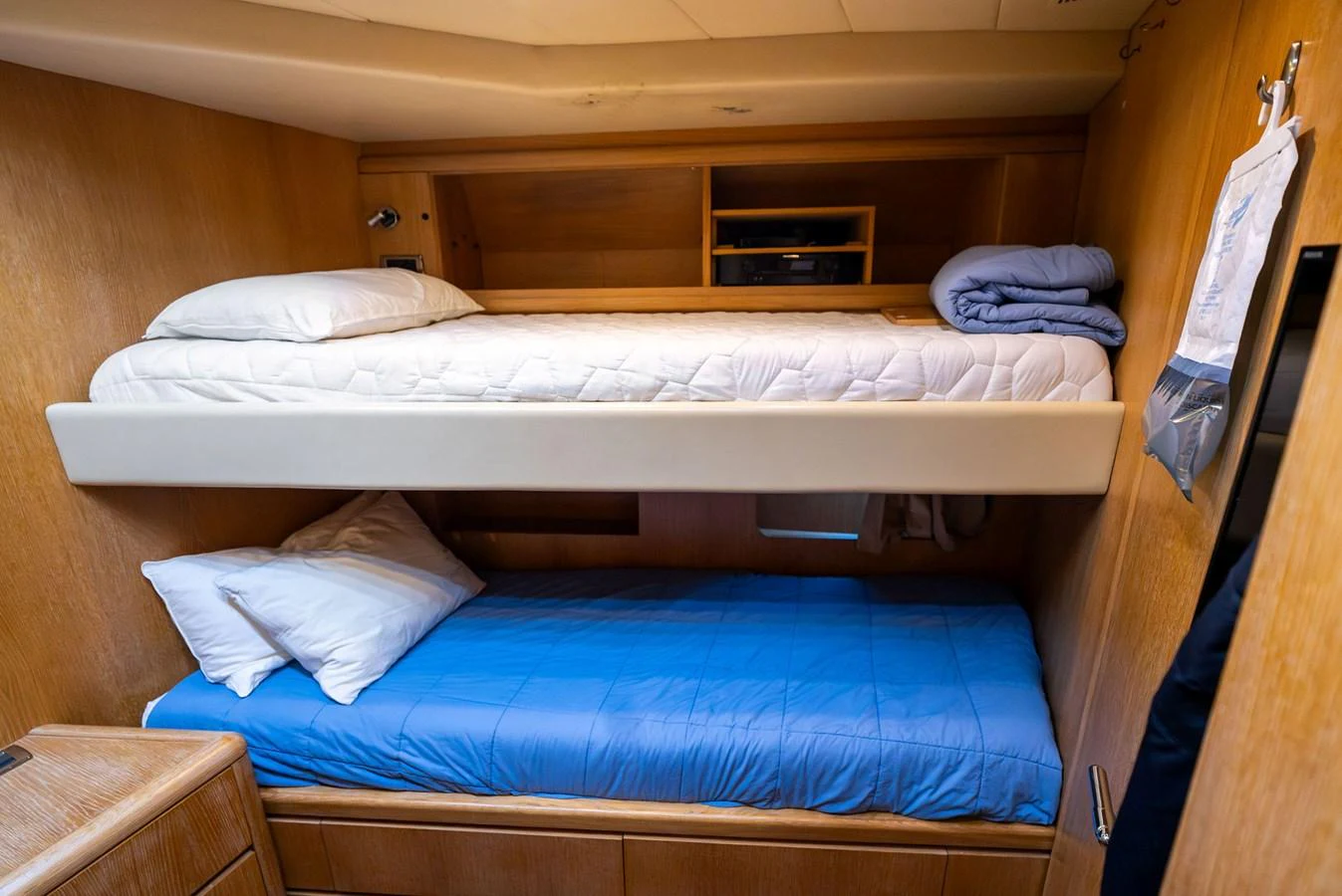 The cozy bunk cabin features wooden paneling and comfortable bedding for a restful sleep. aboard INCOGNITO Yacht for Sale
