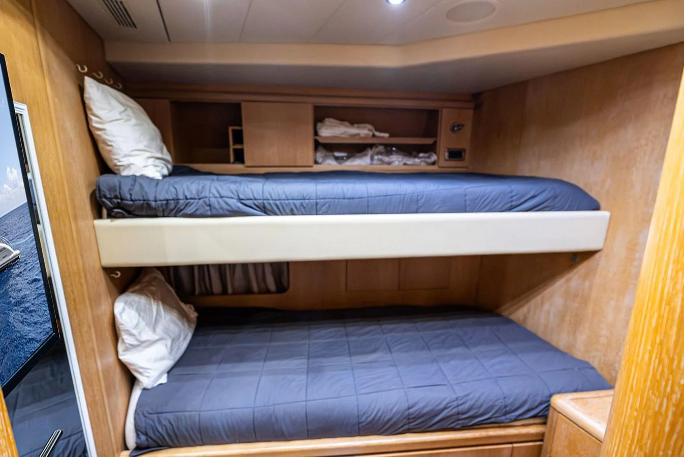 The cozy bunk room features neatly arranged beds with soft bedding, perfect for a restful night's sleep. aboard INCOGNITO Yacht for Sale