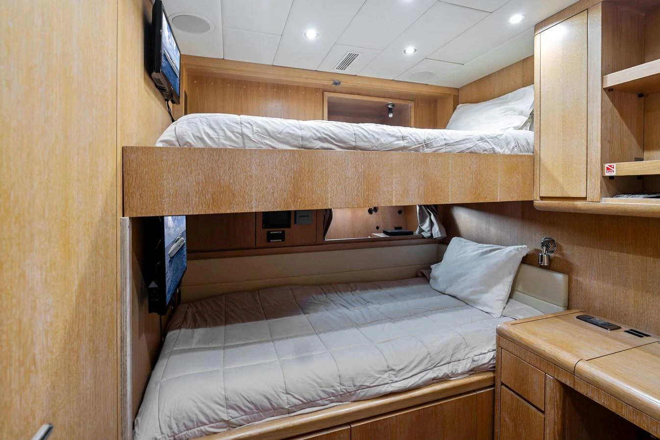 The cozy cabin features bunk beds with warm wooden finishes and modern amenities. aboard INCOGNITO Yacht for Sale