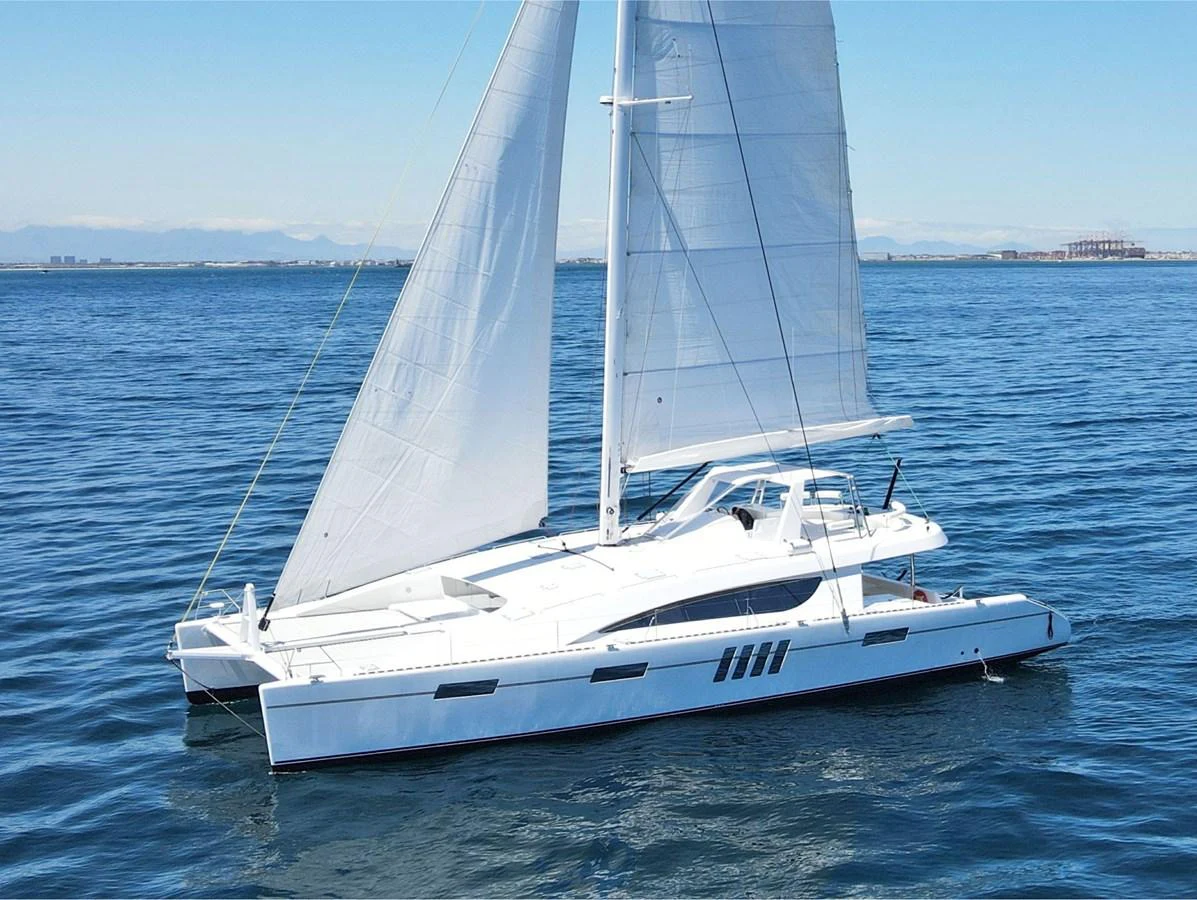 A sleek and modern catamaran sails gracefully on calm waters under a clear blue sky. aboard SILHOUETTE 800 Yacht for Sale