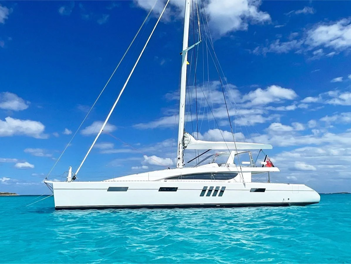 A sleek sailing yacht glides through pristine turquoise waters under a vibrant blue sky. aboard SILHOUETTE 800 Yacht for Sale