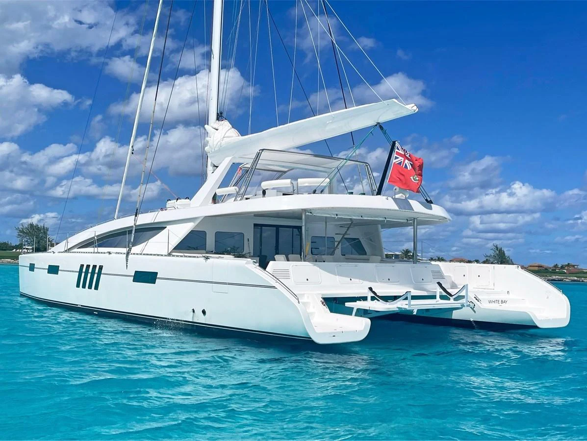 A sleek catamaran yacht glides gracefully on turquoise waters under a clear blue sky. aboard SILHOUETTE 800 Yacht for Sale