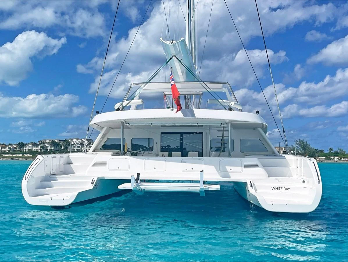 A pristine white catamaran floats on clear turquoise waters under a bright blue sky. aboard SILHOUETTE 800 Yacht for Sale