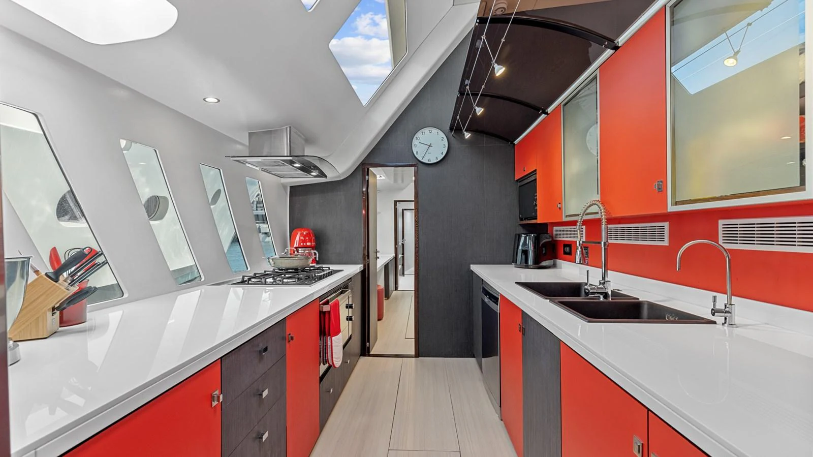 The modern galley features sleek red cabinetry, ample counter space, and large windows for natural light. aboard SILHOUETTE 800 Yacht for Sale