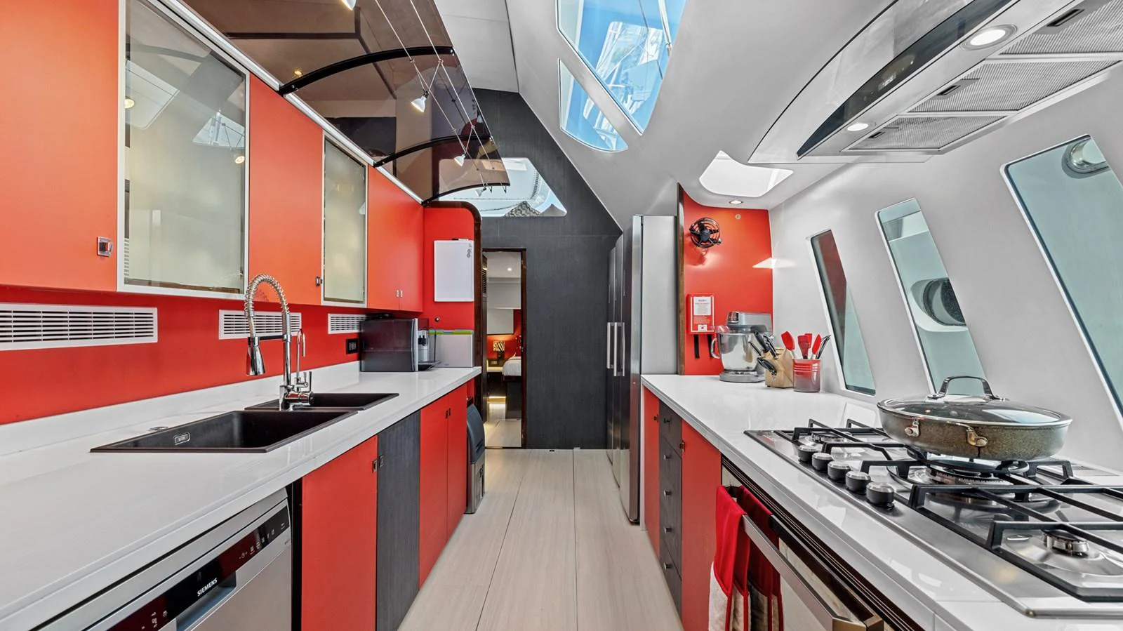 The galley features modern appliances and sleek red cabinetry, creating a vibrant and functional space. aboard SILHOUETTE 800 Yacht for Sale