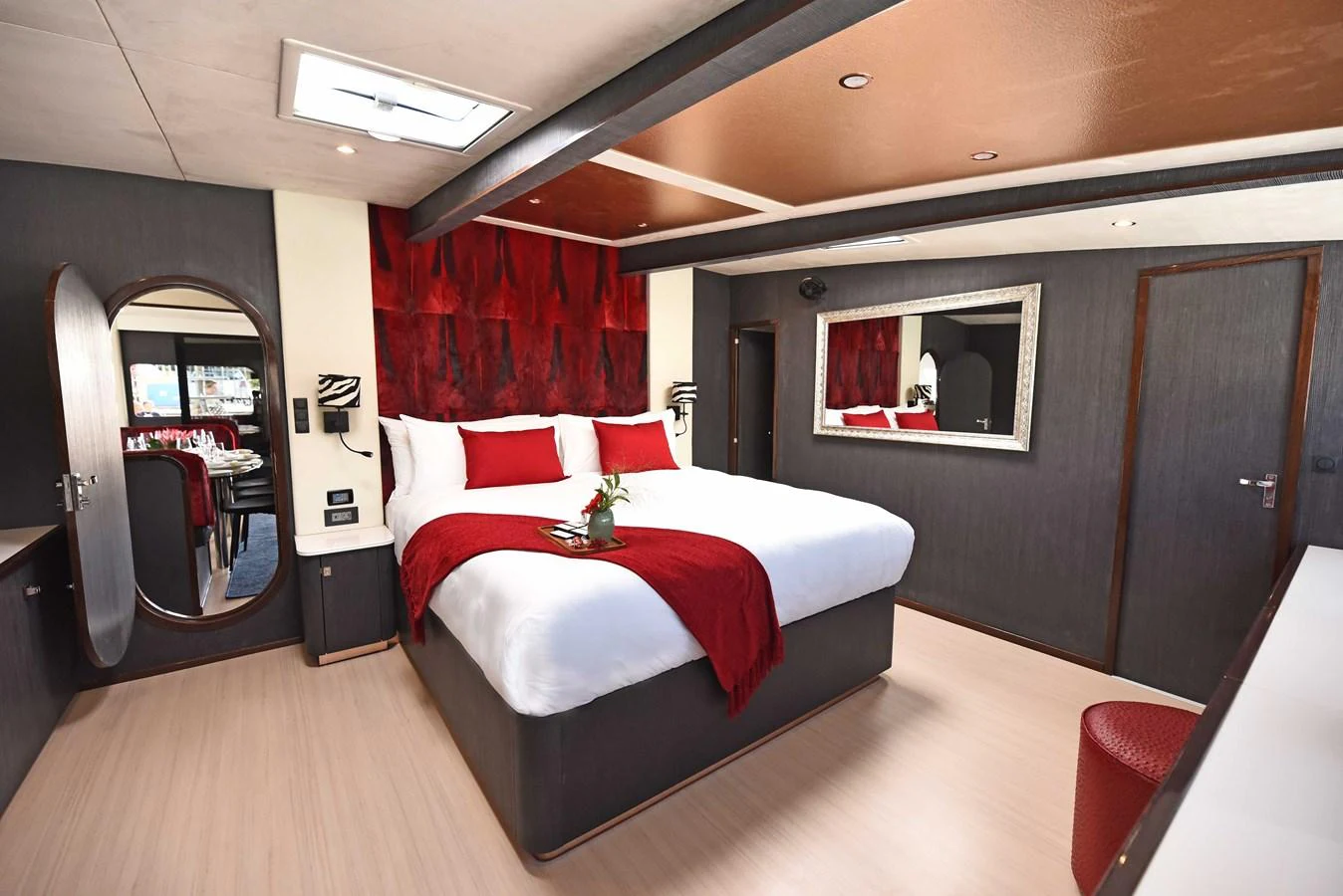 The master stateroom features a luxurious bed with red accents and modern decor. aboard SILHOUETTE 800 Yacht for Sale