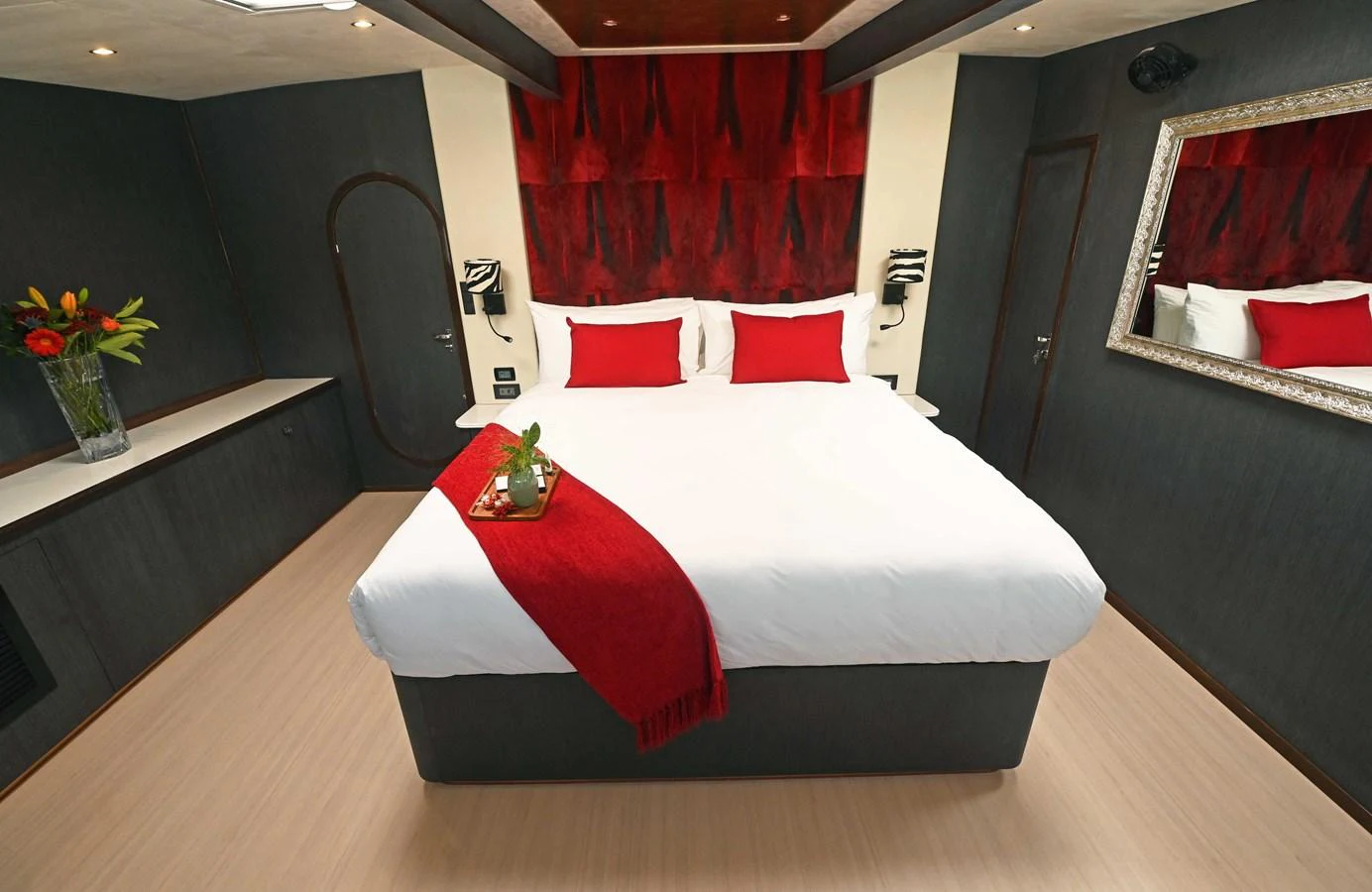 The stateroom features a luxurious bed with red accents and modern decor. aboard SILHOUETTE 800 Yacht for Sale