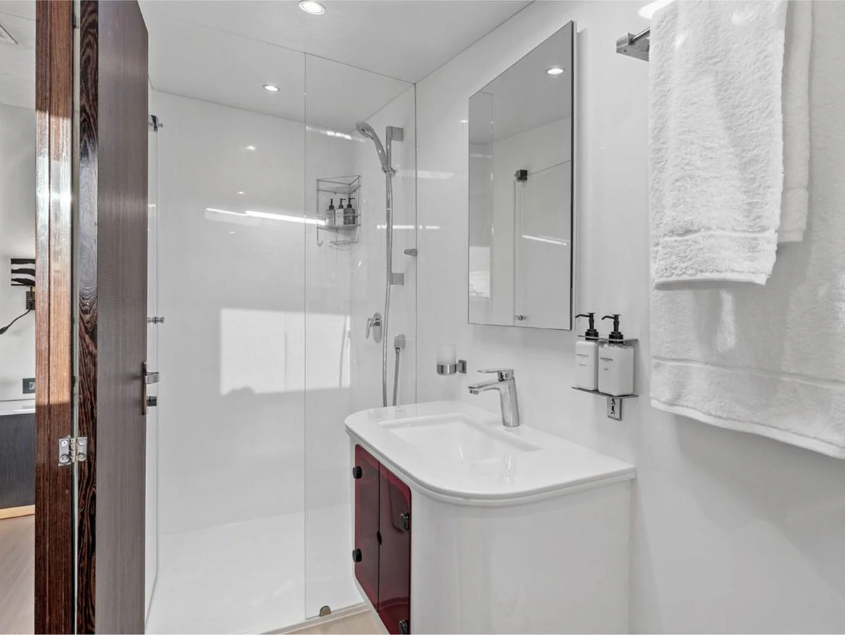 The yacht's bathroom features a sleek, modern design with a glass-enclosed shower and contemporary fixtures. aboard SILHOUETTE 800 Yacht for Sale