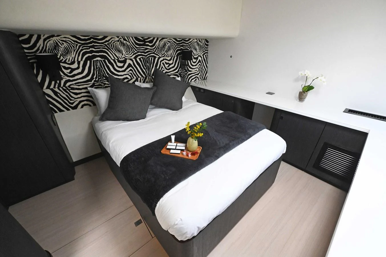 A luxurious stateroom featuring a comfortable bed with stylish zebra-patterned headboard and modern decor. aboard SILHOUETTE 800 Yacht for Sale