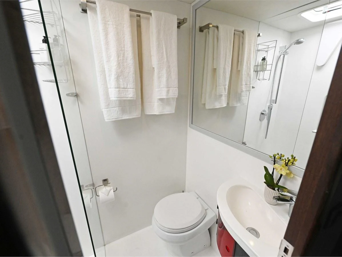 The yacht's bathroom features a modern design with white fixtures and fresh towels. aboard SILHOUETTE 800 Yacht for Sale