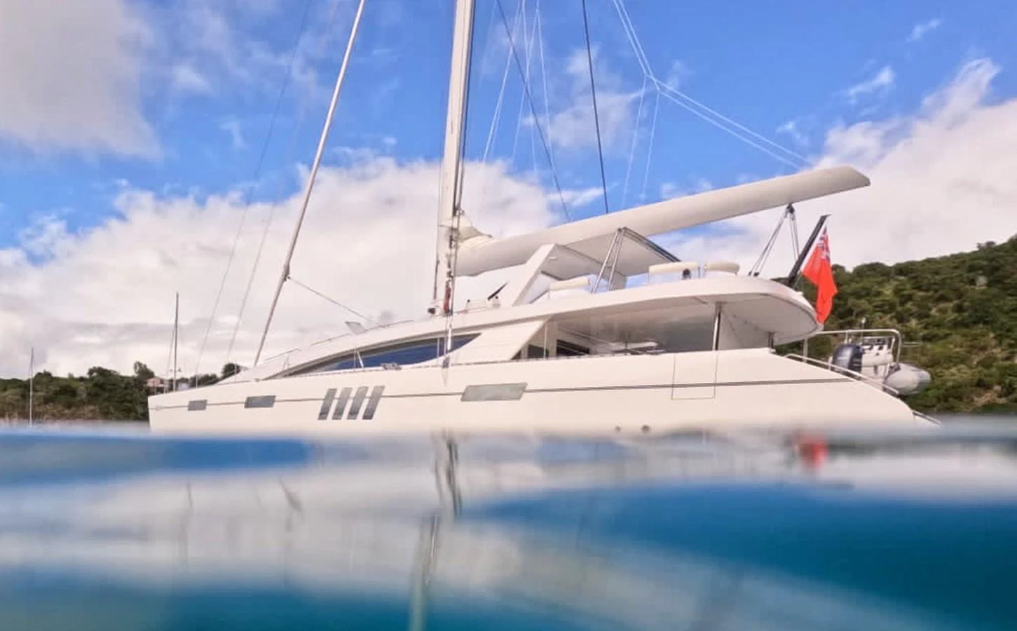 A sleek yacht with a modern design is anchored in calm waters, showcasing its elegant profile against a scenic backdrop. aboard SILHOUETTE 800 Yacht for Sale