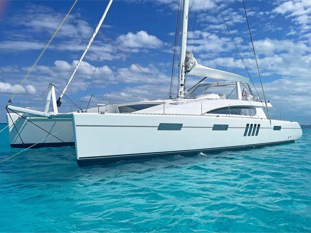 A sleek and modern catamaran yacht glides gracefully on turquoise waters under a clear blue sky. aboard SILHOUETTE 800 Yacht for Sale