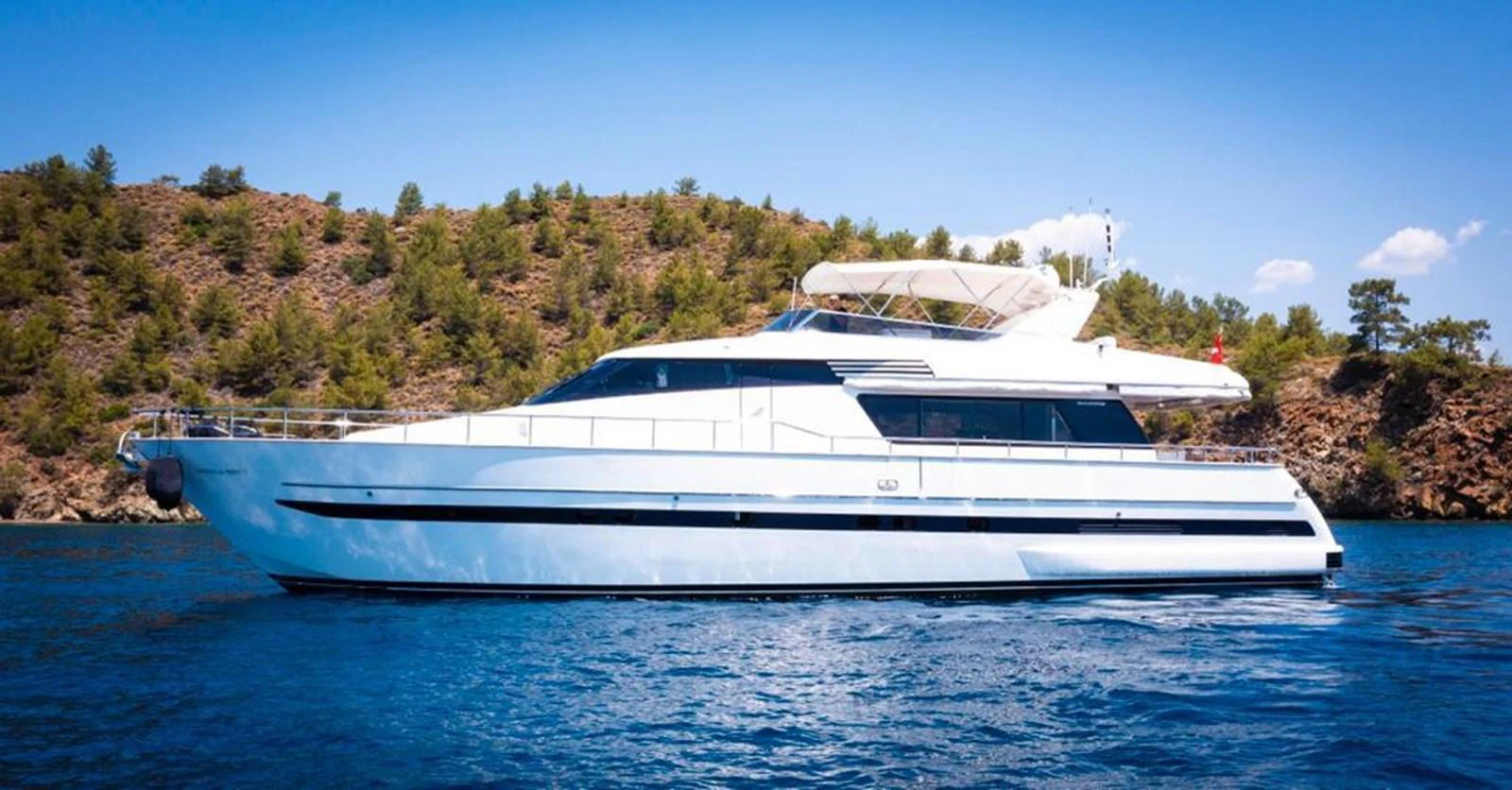 A sleek and modern yacht cruising on calm waters with a scenic backdrop. aboard BARBAROSSA MORATTI Yacht for Sale