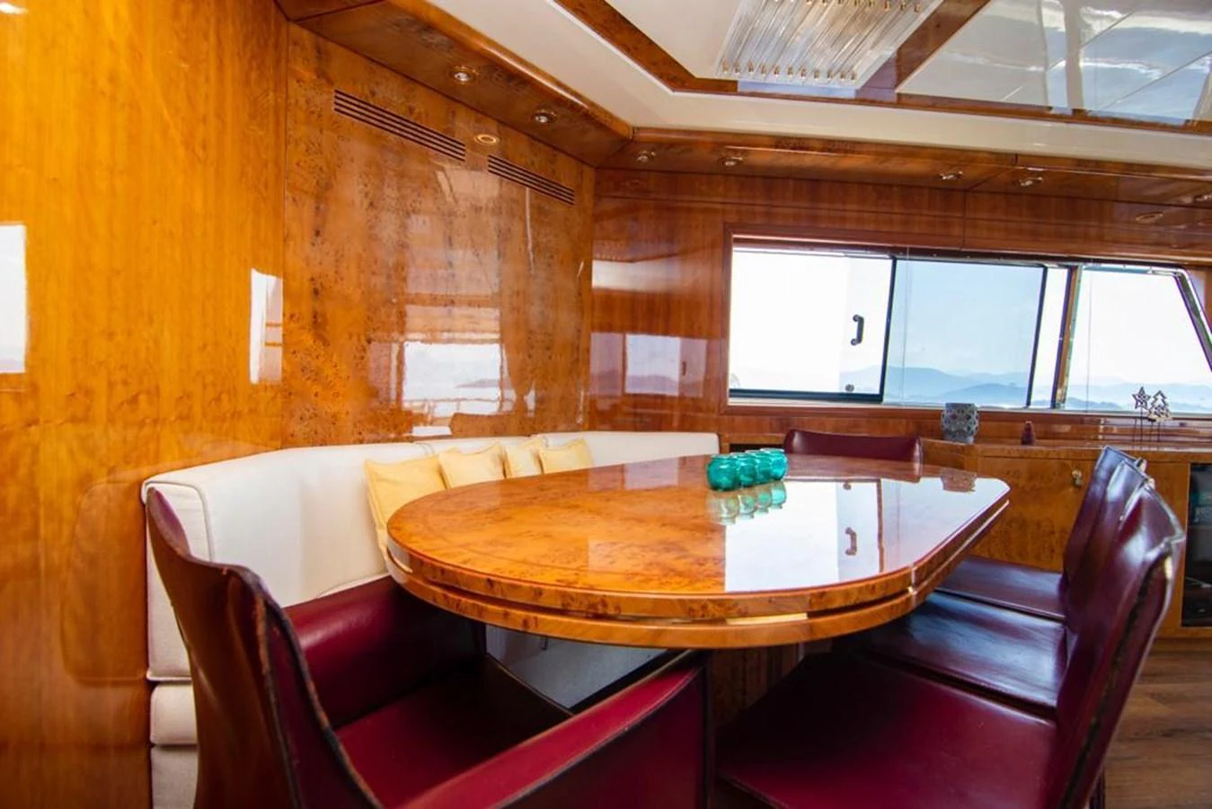 The yacht's dining area features a polished wooden table with comfortable seating and large windows offering scenic views. aboard BARBAROSSA MORATTI Yacht for Sale