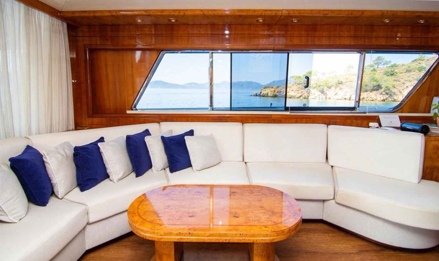 The salon features a spacious seating area with a large window offering stunning views of the sea. aboard BARBAROSSA MORATTI Yacht for Sale
