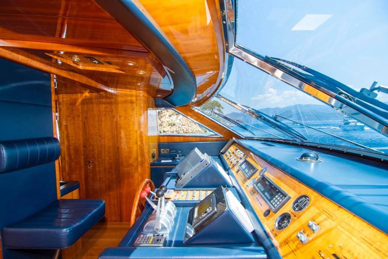 The helm station features luxurious wood finishes and state-of-the-art navigation equipment with panoramic views. aboard BARBAROSSA MORATTI Yacht for Sale