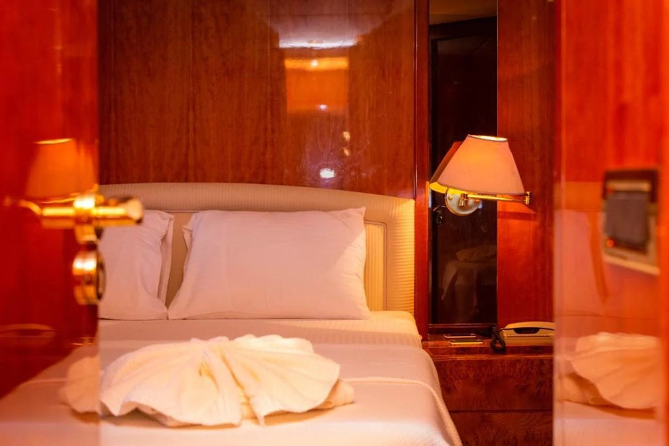 A cozy stateroom with warm lighting and elegant wood paneling. aboard BARBAROSSA MORATTI Yacht for Sale