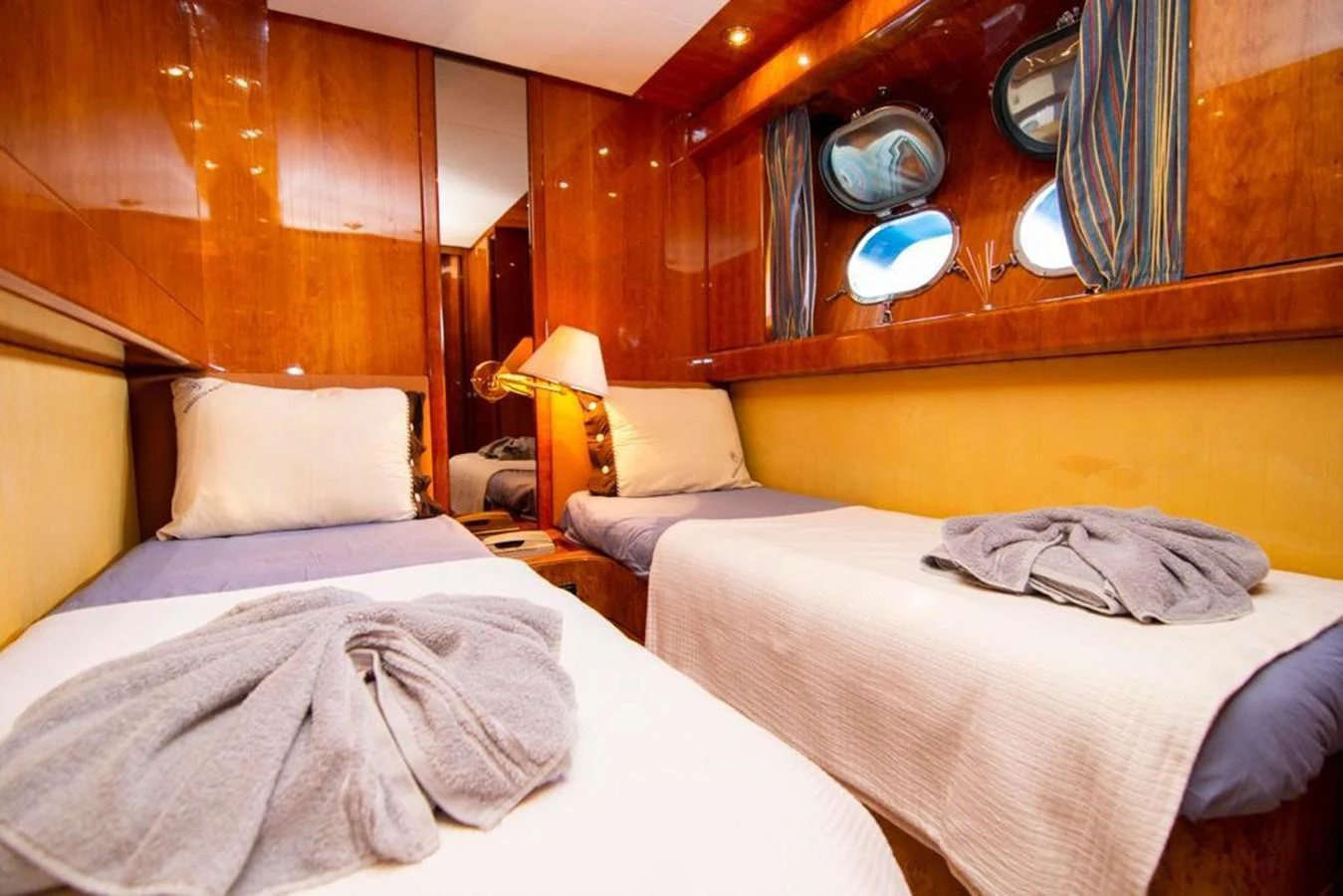 A cozy twin stateroom with warm wooden finishes and soft lighting. aboard BARBAROSSA MORATTI Yacht for Sale