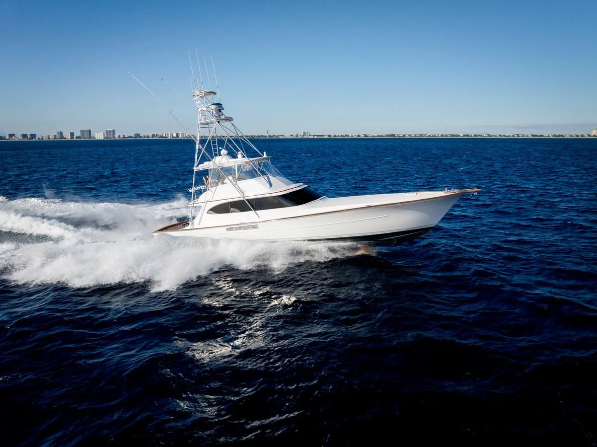A sleek yacht cruises swiftly through the open water under a clear blue sky. aboard NEVER SAY NEVER Yacht for Sale