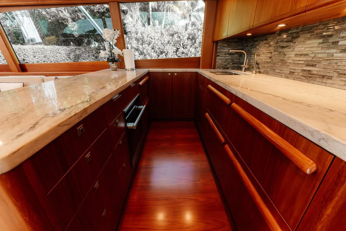The galley features elegant wood cabinetry, a sleek countertop, and modern appliances. aboard NEVER SAY NEVER Yacht for Sale