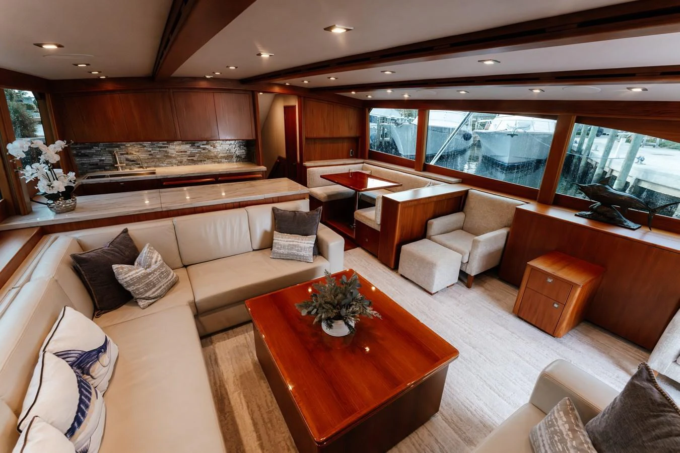 The yacht's salon features elegant wood finishes and comfortable seating with large windows offering a view of the marina. aboard NEVER SAY NEVER Yacht for Sale